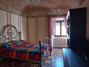 a bedroom with a bed and a window at Casa Marzocco in Pomarance