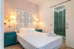 a bedroom with a bed and a glass shower at PLAZA DE CASTILLA Apartments in Madrid