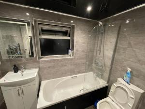 a bathroom with a shower and a toilet and a sink at Private Luxury Rooms RM2 in Northenden