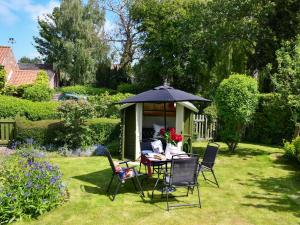 einen Tisch und Stühle unter einem Sonnenschirm in einem Garten in der Unterkunft 2 Bed in York 56125 in Elvington