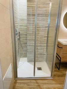 a shower with a glass door in a room at Mauris Home in Tortolì