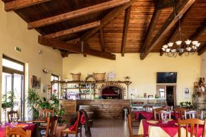 a restaurant with tables and chairs and a fireplace at Agriturismo Pinelli in Plataci