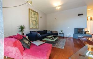 a living room with a red couch and a table at Villa Rasko with private heated pool in Podstrana