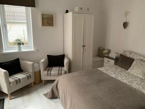 a bedroom with a bed and a chair and a cabinet at Country house in Svidník