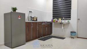 a kitchen with a stainless steel refrigerator and a sink at Akasia Homestay Kuantan in Kuantan +2 photos