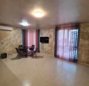 ein Wohnzimmer mit einem Tisch, Stühlen und einem TV in der Unterkunft Fully furnished Apartment in Warna