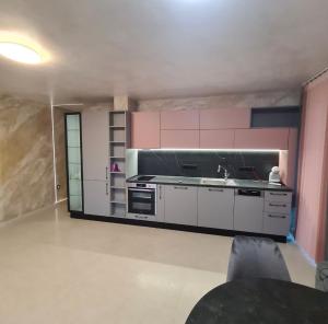 eine Küche mit rosa Schränken und einem Waschbecken in der Unterkunft Fully furnished Apartment in Warna