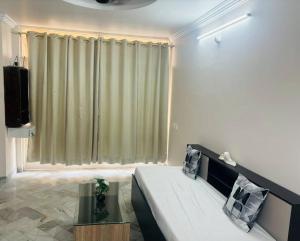 a living room with a couch and a large window at Simhagiri Sea Holiday Inn in Visakhapatnam