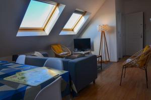 - un salon avec des lucarnes et un canapé bleu dans l'établissement Camelia; Beau logement lumineux, avec vue sur mer, à Wimereux