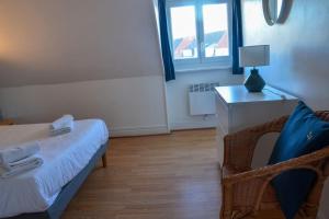 une chambre avec un lit, une table et une fenêtre dans l'établissement Camelia; Beau logement lumineux, avec vue sur mer, à Wimereux