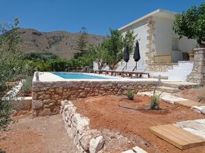 a swimming pool with umbrellas in front of a house at PALACE Mountain view in Megála Khoráfia