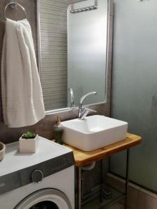 a bathroom with a sink and a washing machine at Ikaros Lodge in Agia Pelagia