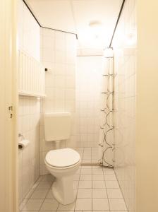 La salle de bains blanche est pourvue d'une douche et de toilettes. dans l'établissement Appartementen Zuiderstrand Zoutelande, à Zoutelande
