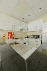 a kitchen with white cabinets and a counter top at Chic Apartment Dubai Marina in Dubai