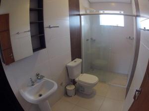 a bathroom with a toilet and a sink and a shower at Residencial Ferrugem Beira Mar in Garopaba +19 photos