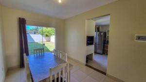 a dining room and kitchen with a table and chairs at Ferrugem Beira Mar in Garopaba