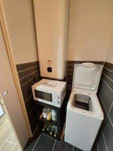 a small kitchen with a sink and a microwave at Chambre table d'hôtes Anne-Marie et Jean-Christophe in Ferrières-en-Bray