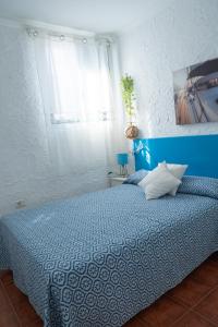 a bedroom with a blue bed and a window at Punta Mar in Güimar