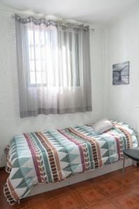 a bed sitting in a bedroom with a window at Punta Mar in Güimar