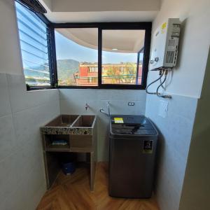 ein kleines Bad mit einem Waschbecken und einem Fenster in der Unterkunft apartamento banderas 2 in Pereira