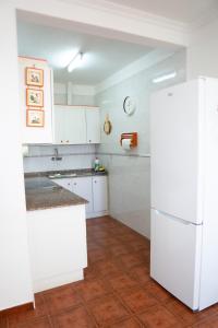 a kitchen with white cabinets and a white refrigerator at Punta Mar in Güimar