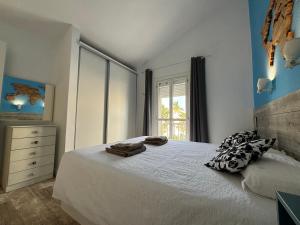 1 dormitorio con cama blanca y ventana en Canarian Green Oasis by luca properties gran canaria, en Maspalomas