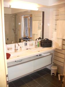 La salle de bains est pourvue d'un lavabo et d'un grand miroir. dans l'établissement Hotel Stülzis, à Lech am Arlberg