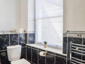 a bathroom with a toilet and a window at Church View in Cockermouth