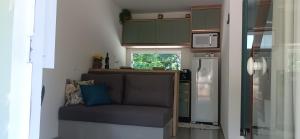 a small kitchen with a couch and a refrigerator at Chalé Girassol in Jaraguá do Sul