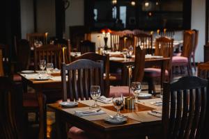 un restaurante con mesas de madera y sillas con copas de vino en Villa Blanca Cloud Forest Hotel & Retreat, en San Ramón