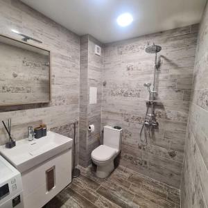 Un baño con inodoro, lavabo y ducha. en Fully Furnished Apartment-B7, en Varna