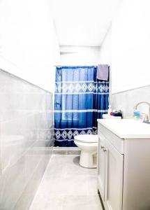 een badkamer met een toilet en een blauw douchegordijn bij Modern 1 Bedroom Apartment close Falls and Casino in Niagara Falls