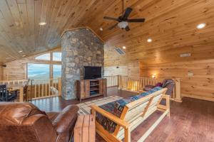 a living room with leather furniture and a stone fireplace at Blue Ridge Bliss Gorgeous home with hot tub & stunning views in Weaverville