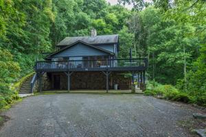 a house in the woods with a balcony at Blue Ridge Bliss Gorgeous home with hot tub & stunning views in Weaverville