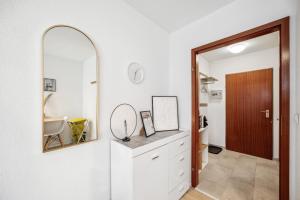 ein Bad mit einem Spiegel und einer weißen Kommode in der Unterkunft Sali-Bayreuth SB19 Komfortable Wohnung in der Nähe des Zentrums in Bayreuth