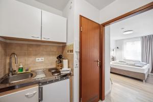 eine Küche mit einem Waschbecken und einem Bett im Hintergrund in der Unterkunft Sali-Bayreuth SB19 Komfortable Wohnung in der Nähe des Zentrums in Bayreuth