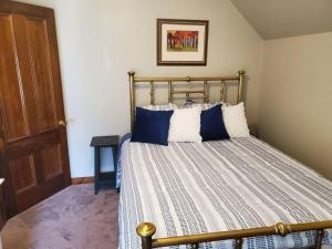 um quarto com uma cama com almofadas azuis e brancas em Farmhouse Chic in the Heart of the Sebago Lakes Region em Raymond