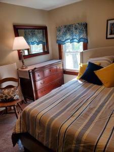 um quarto com uma cama, uma cómoda e uma janela em Farmhouse Chic in the Heart of the Sebago Lakes Region em Raymond
