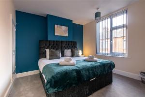 una camera da letto con un grande letto con due cuscini sopra di 2 Bedroom House in the Heart of Leicester a Leicester