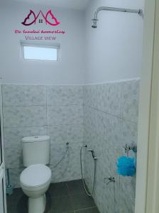 a bathroom with a white toilet and a shower at D landai homestay in Pekan