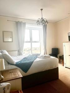 a bedroom with a large bed with a window at The Wash & Tope in Hunstanton