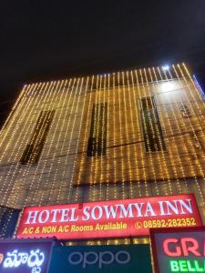um edifício com um monte de placas na frente dele em HOTEL SOWMYA INN em Ongole