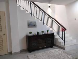un escalier dans une maison avec une commode marron et des plantes dans l'établissement Sierra Hill Homestay 2, 