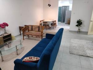 - un salon avec un canapé bleu et une table dans l'établissement Sierra Hill Homestay 2, 