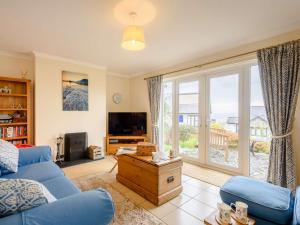 a living room with a blue couch and a large window at 3 Bed in Harlech 42153 in Harlech