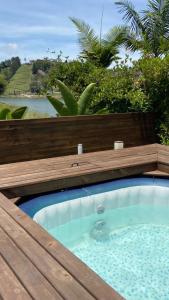 a jacuzzi tub in a wooden deck with a view at Glamping La Cepa GUATAPÉ in Guatapé