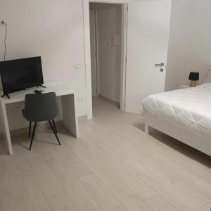 een slaapkamer met een bed en een bureau met een computer bij mya luxury rooms and wellness in Melendugno