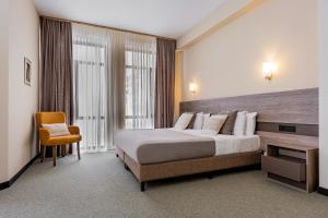 a hotel room with a large bed and a chair at DiliJazz Hotel & Restaurant in Dilijan