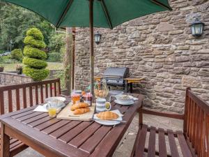 a picnic table with food on it with an umbrella at 2 Bed in Abergavenny BN187 in Clydach