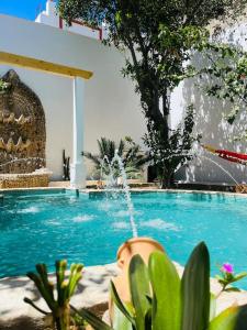 a swimming pool with a fountain in the middle at Espectacular Casa_Isma in Puerto Real